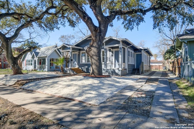 view of front of house with entry steps, fence, and a residential view