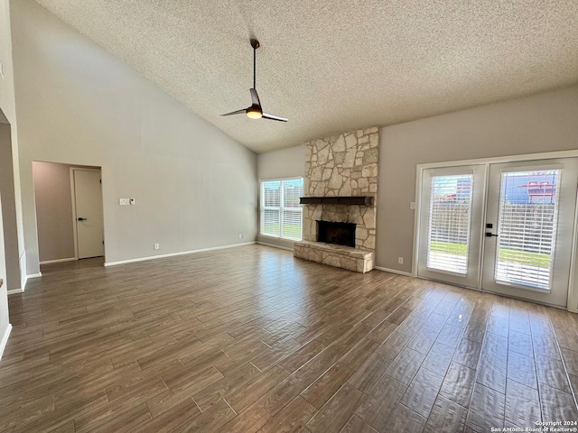 unfurnished living room featuring ceiling fan, a textured ceiling, a fireplace, and wood finished floors