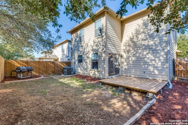 back of house featuring a fenced backyard, a wooden deck, and central air condition unit