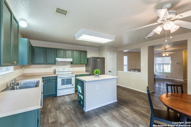 kitchen with electric range, high quality fridge, light countertops, under cabinet range hood, and a sink