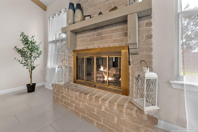 room details featuring a brick fireplace and baseboards