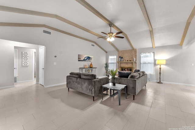 living area with lofted ceiling with beams, a brick fireplace, ceiling fan, and visible vents