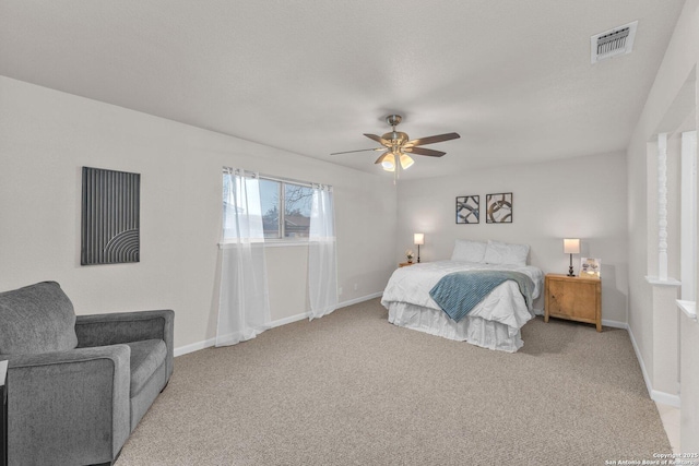 bedroom featuring baseboards, visible vents, ceiling fan, and light colored carpet