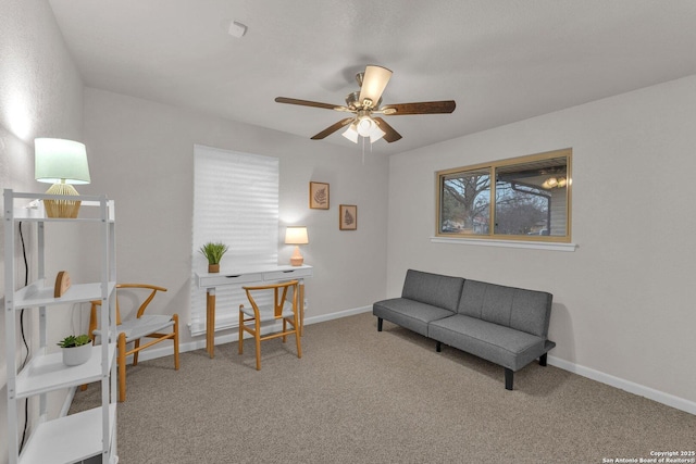 living area featuring ceiling fan, carpet flooring, and baseboards