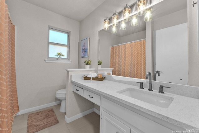 bathroom featuring toilet, tile patterned floors, vanity, and baseboards