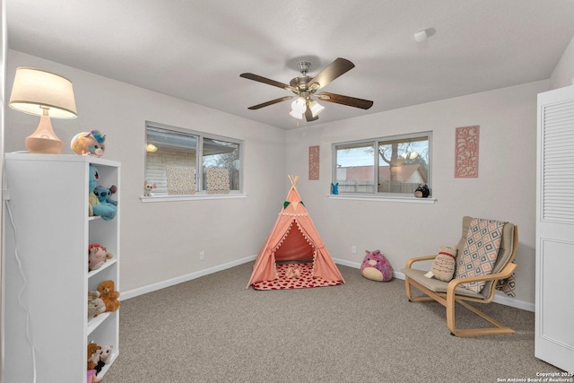 playroom with a ceiling fan, carpet, and baseboards