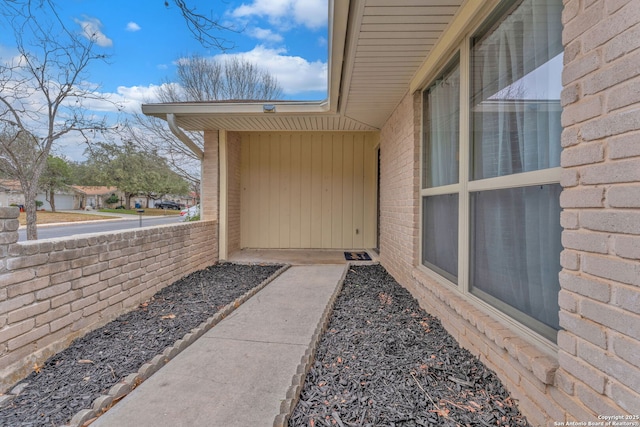 doorway to property featuring brick siding