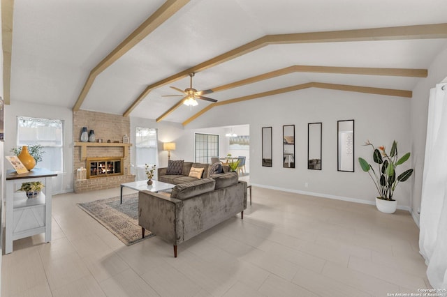 living room with vaulted ceiling with beams, ceiling fan with notable chandelier, a fireplace, and baseboards