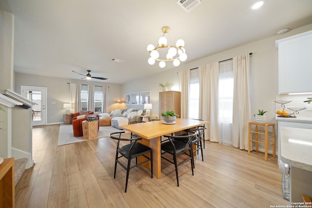 dining area featuring light wood-type flooring, a healthy amount of sunlight, visible vents, and stairway