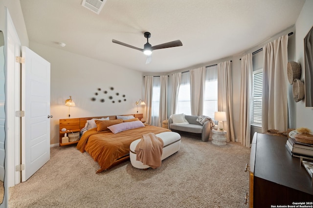 bedroom featuring visible vents, ceiling fan, and light carpet