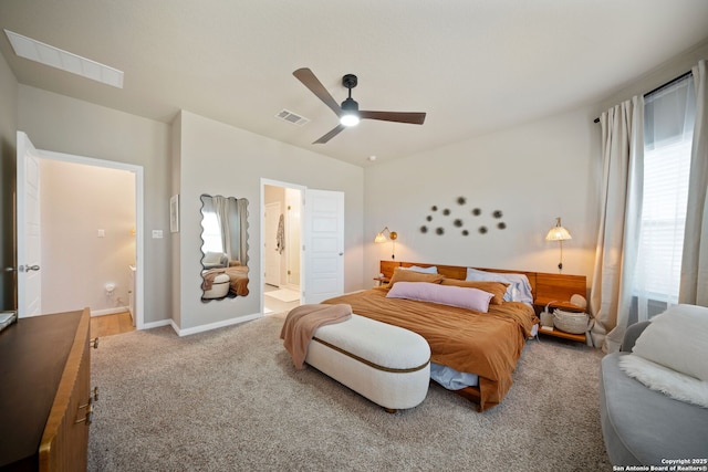 carpeted bedroom featuring ceiling fan, ensuite bath, visible vents, and baseboards