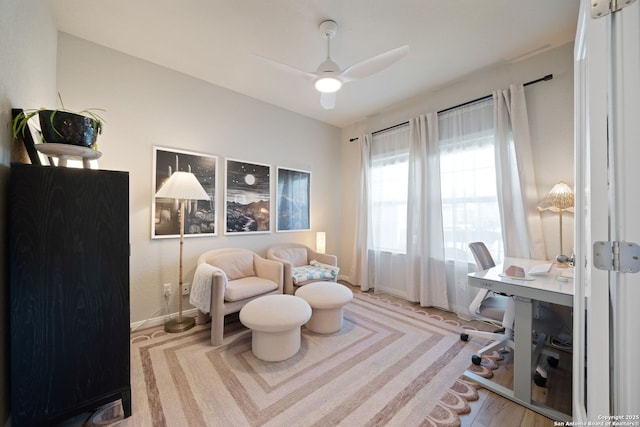 home office with baseboards, ceiling fan, and wood finished floors