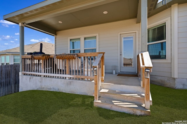 doorway to property featuring fence and a yard