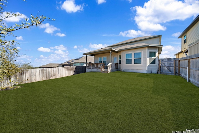 rear view of property with a yard and a fenced backyard