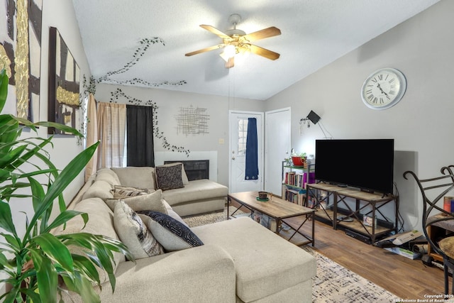 living room with lofted ceiling, a textured ceiling, a ceiling fan, and wood finished floors