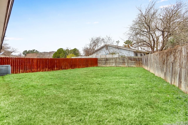 view of yard featuring a fenced backyard and central AC