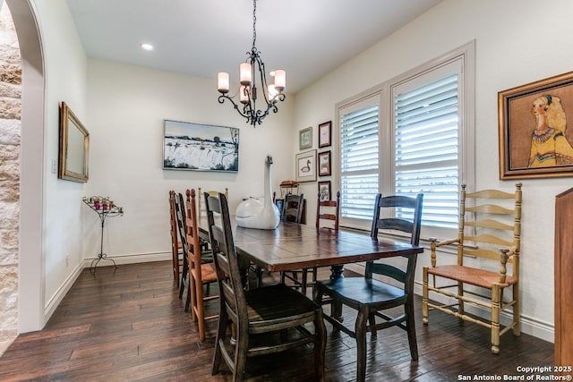 dining room featuring arched walkways, dark wood-style flooring, baseboards, and an inviting chandelier