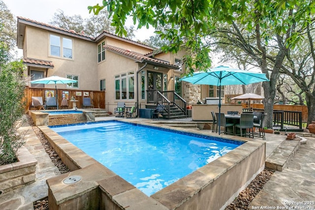 view of pool featuring a fenced in pool, fence, a hot tub, and a patio