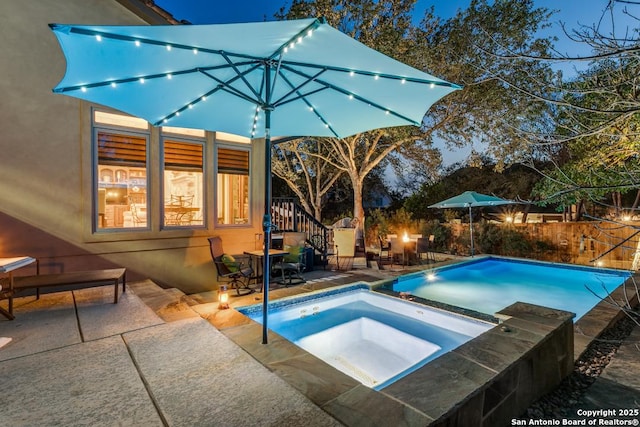 view of pool featuring a patio area, fence, a fenced in pool, and an in ground hot tub