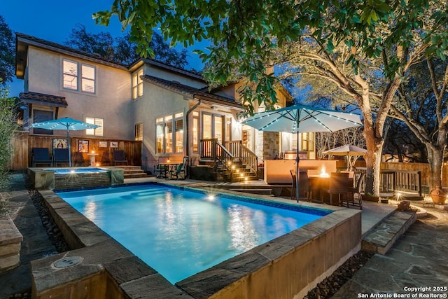 outdoor pool with exterior bar, fence, a patio, and an in ground hot tub