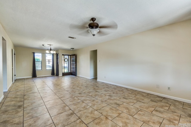 empty room with visible vents, a textured ceiling, baseboards, and ceiling fan with notable chandelier