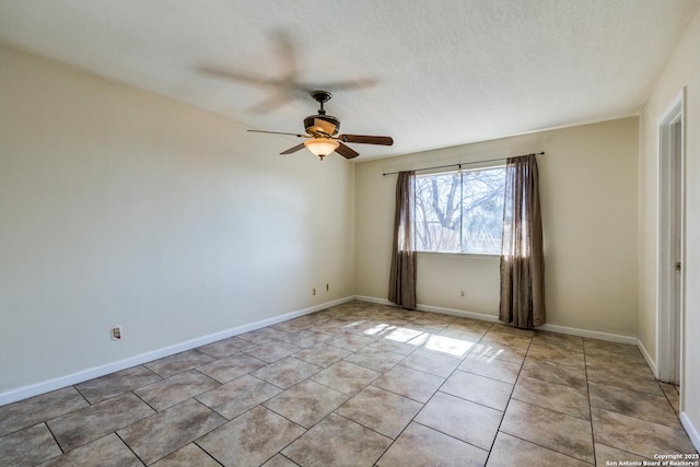 spare room with light tile patterned floors, a textured ceiling, a ceiling fan, and baseboards