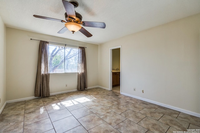 spare room featuring light tile patterned floors, ceiling fan, a textured ceiling, and baseboards