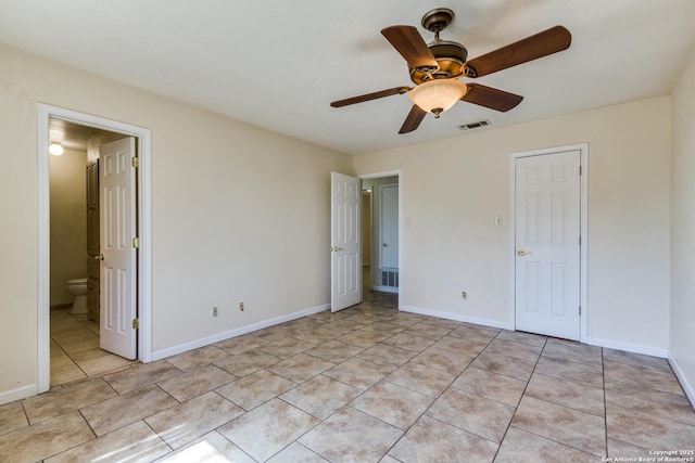 unfurnished bedroom featuring ensuite bath, light tile patterned floors, baseboards, and visible vents