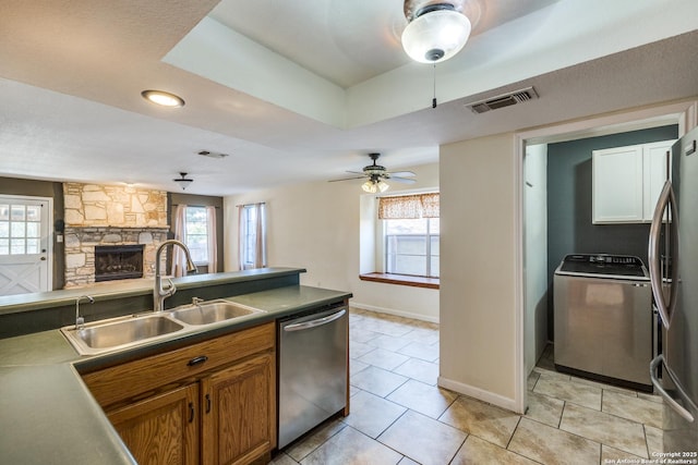 kitchen with visible vents, washer / clothes dryer, stainless steel appliances, a healthy amount of sunlight, and a sink