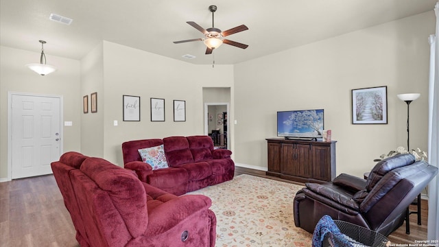 living area featuring a ceiling fan, baseboards, visible vents, and wood finished floors