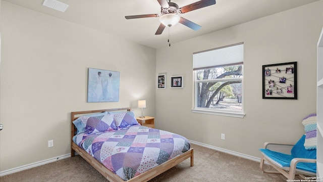 carpeted bedroom featuring a ceiling fan, visible vents, and baseboards