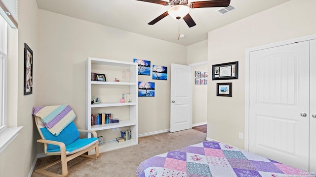 bedroom featuring ceiling fan, light colored carpet, visible vents, baseboards, and a closet