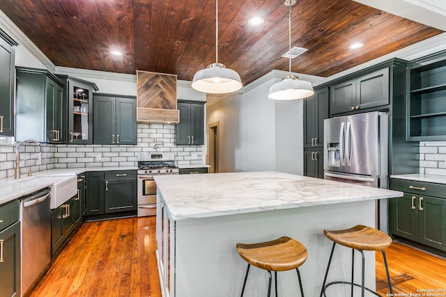 kitchen with decorative light fixtures, a kitchen island, appliances with stainless steel finishes, open shelves, and glass insert cabinets