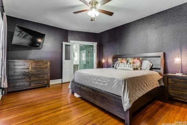 bedroom featuring ceiling fan, connected bathroom, wood finished floors, and a textured wall