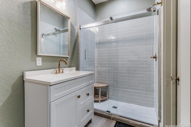 bathroom featuring a textured wall and a stall shower