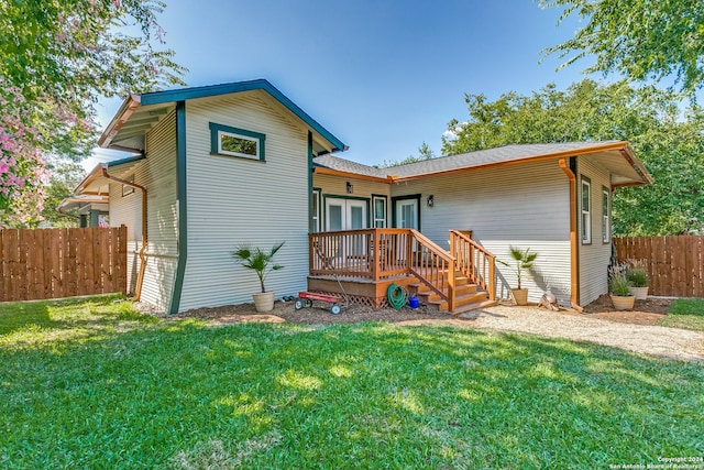 rear view of property featuring fence, a deck, and a yard