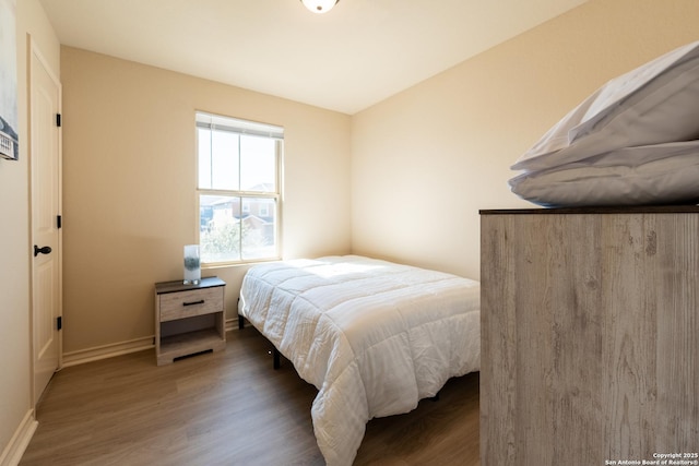 bedroom featuring dark wood-style floors and baseboards