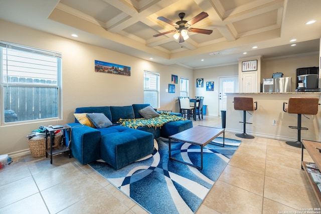 living room featuring light tile patterned floors, coffered ceiling, and a healthy amount of sunlight