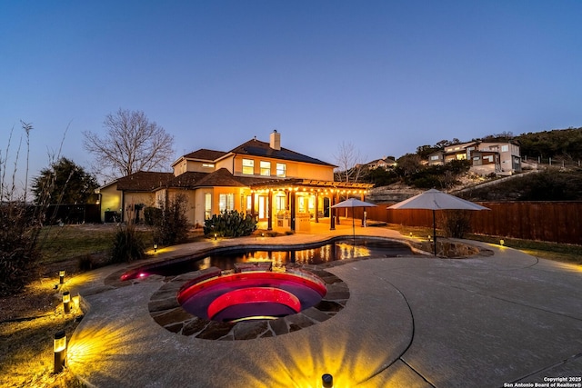 view of swimming pool with a patio area, fence, a fenced in pool, and an in ground hot tub