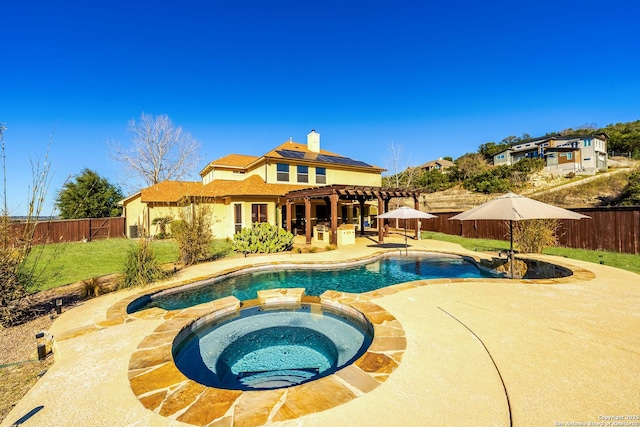 view of pool featuring a patio, a fenced backyard, a pool with connected hot tub, a yard, and a pergola