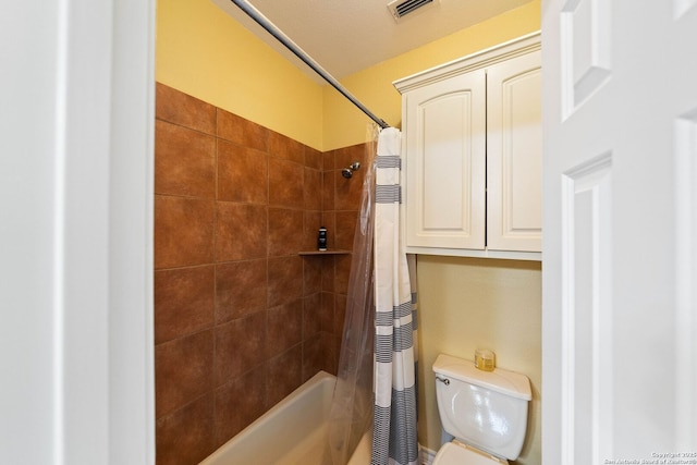 bathroom featuring toilet, visible vents, and shower / bath combo with shower curtain