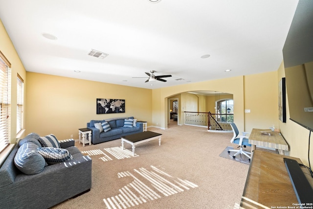 living room featuring arched walkways, recessed lighting, carpet floors, visible vents, and baseboards