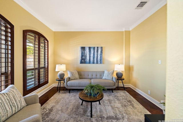 living room with dark wood-style flooring, visible vents, crown molding, and baseboards