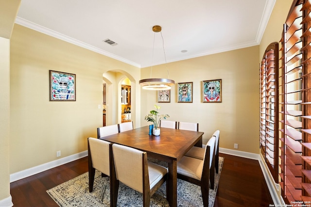 dining room featuring baseboards, visible vents, dark wood-style flooring, and ornamental molding