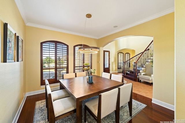 dining area with ornamental molding, stairway, dark wood finished floors, and baseboards