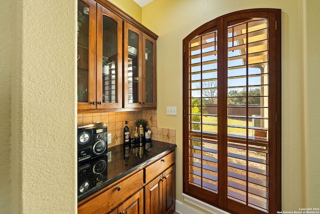 bar featuring arched walkways and tasteful backsplash