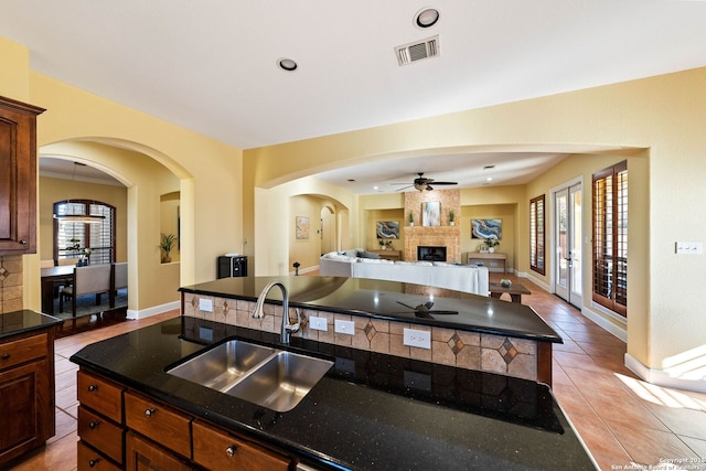 kitchen with visible vents, open floor plan, a center island, a sink, and a wealth of natural light