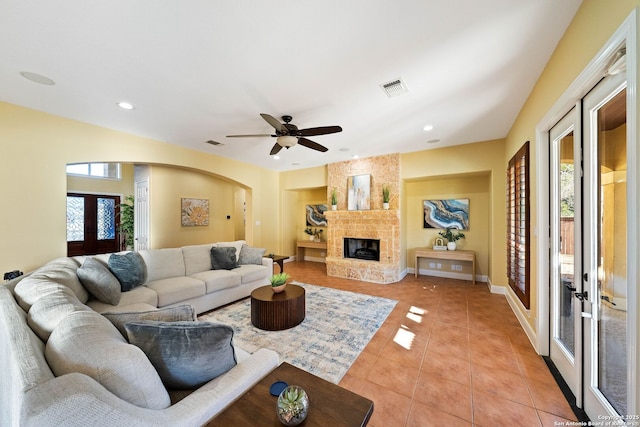 living area with a healthy amount of sunlight, light tile patterned floors, visible vents, and french doors