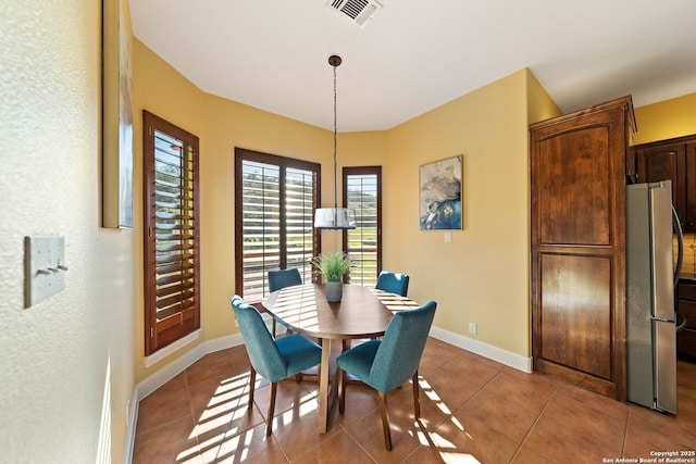 dining area with light tile patterned floors, baseboards, and visible vents