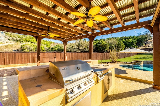 view of patio featuring an outdoor kitchen, a fenced backyard, area for grilling, a sink, and a fenced in pool